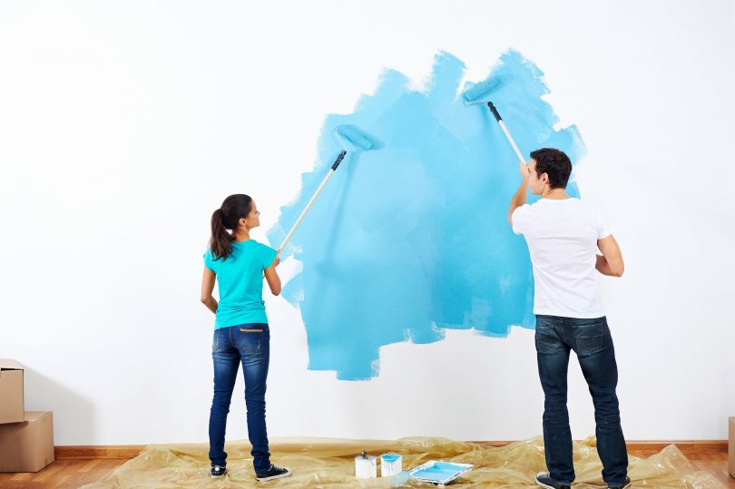 casal pintando a casa de azul piscina