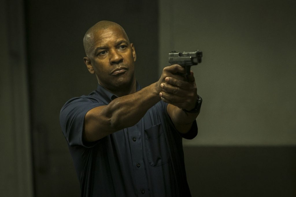 O protetor com uma arma na mão no filme