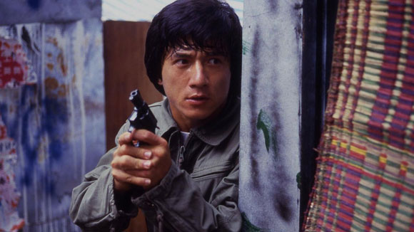 Jackie Chan segurando uma arma no filme Police Story