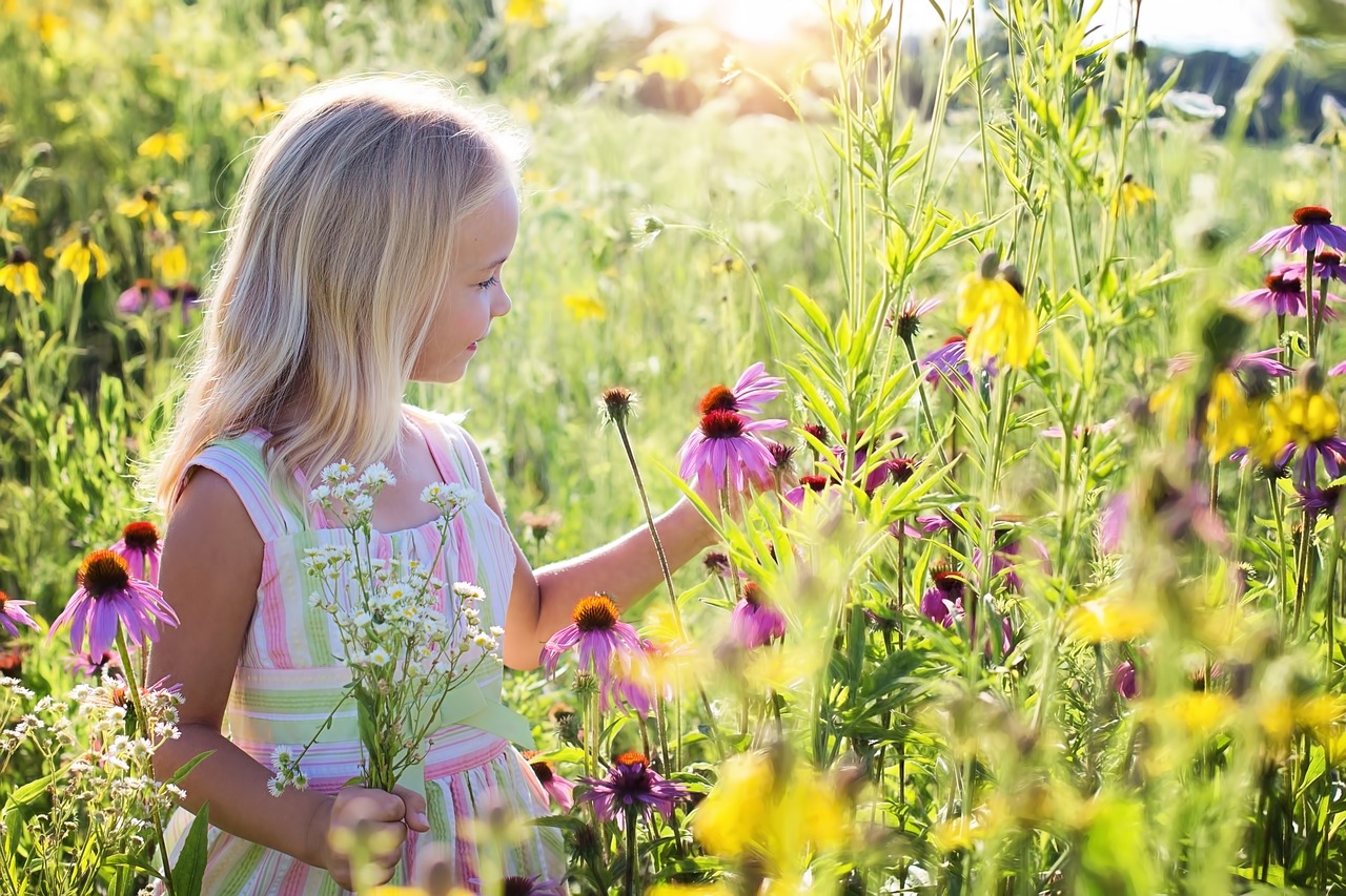 imagem de uma garota feliz em meio as flores em um lindo dia de sol