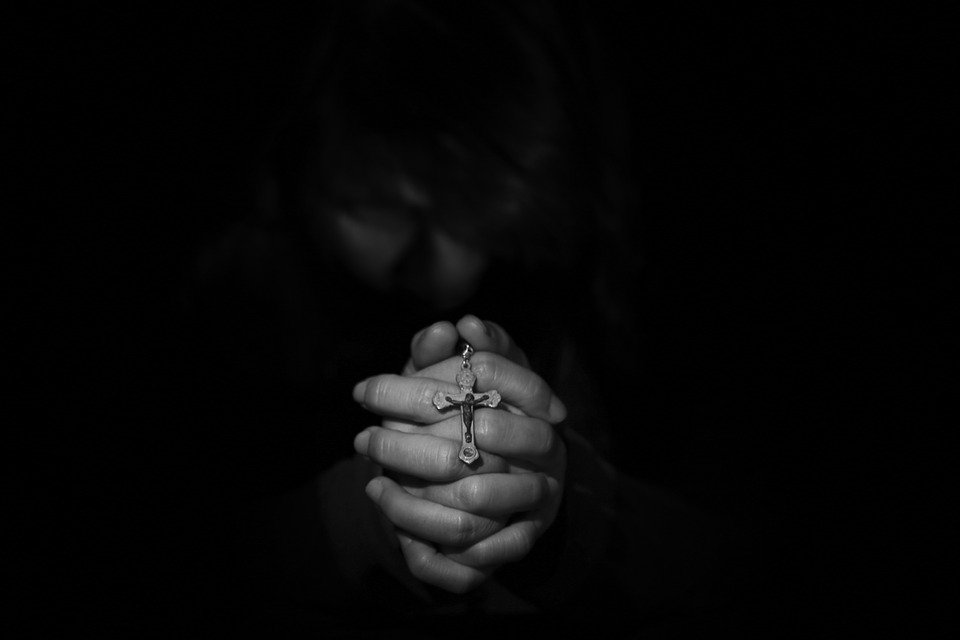 mãos juntas que oram e pedem perdão a Deus