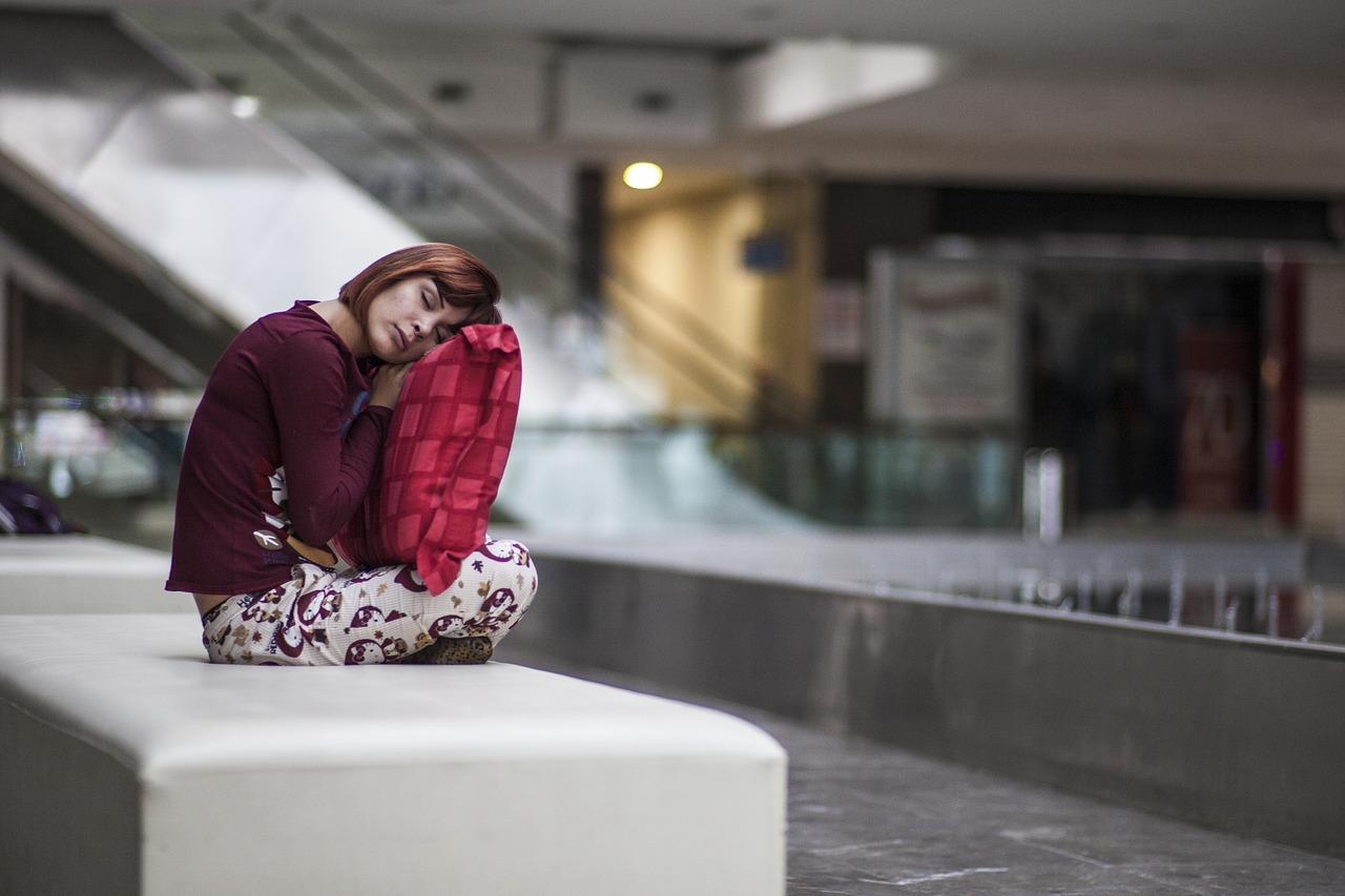 mulher dormindo em público cansada em um banco