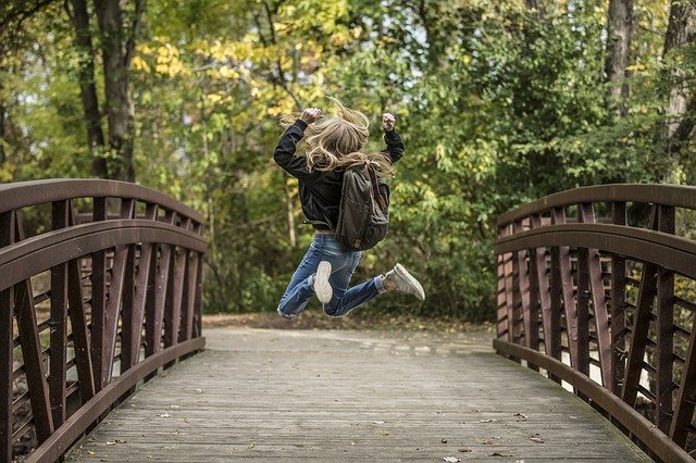 mulher feliz pulando na ponte