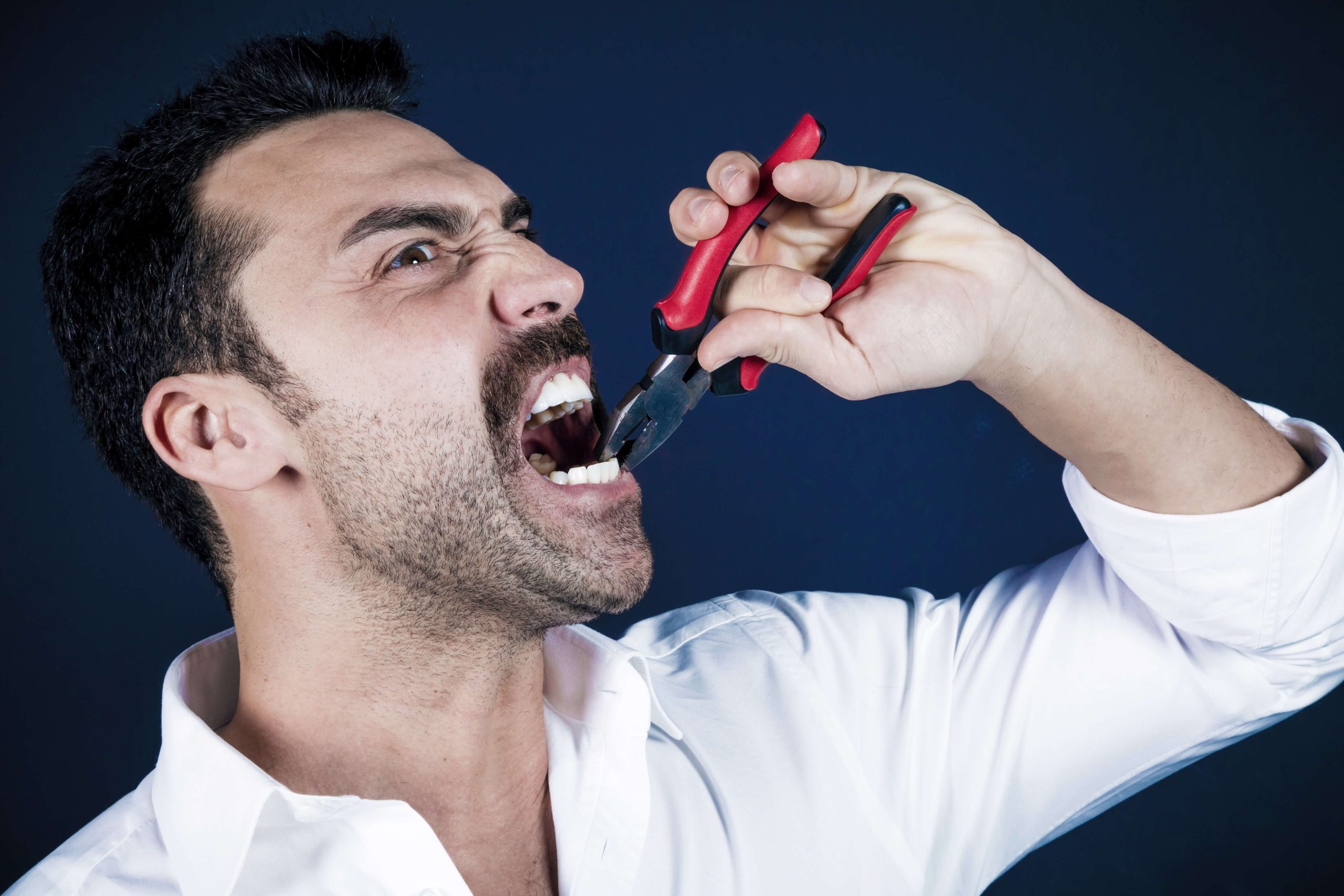 homem arrancando dente com um alicate